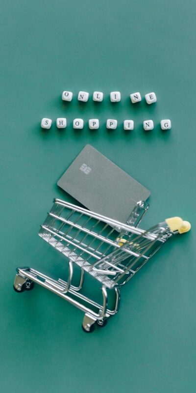 A miniature shopping cart with a credit card illustrates online shopping trends.