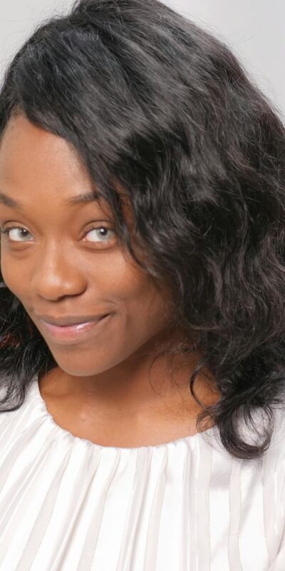 A smiling woman with a credit card, symbolizing online shopping and financial empowerment.