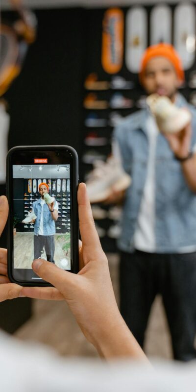 Person filming a shoe shopping experience in a trendy store using a smartphone.